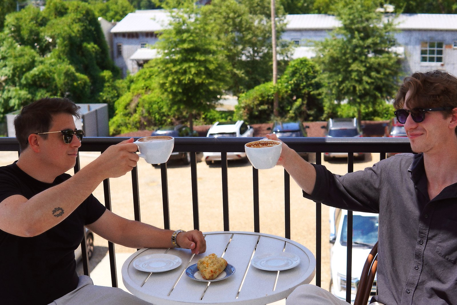 The two Double Shot founders toasting espresso cups at a cafe table