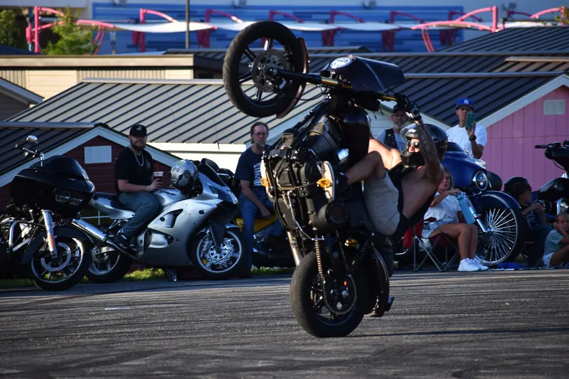 A rider pulling a wheelie in front of the crowd at Eats on 601 in Mocksville